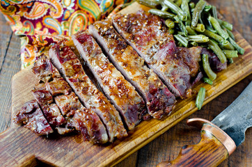 Pork steak with green beans on a wooden table