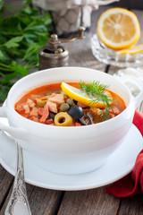 Traditional Russian soup solyanka closeup in a bowl on the table.