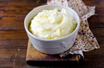 Mashed potatoes in a bowl on a wooden table
