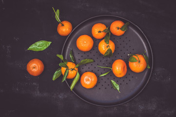 Tangerines on black table, top view