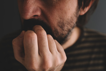 Nervous man bites fingernails