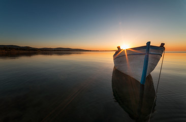 Lonely boat at sunset - Powered by Adobe