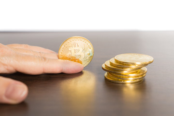 One Bitcoin holding in hand and others beside