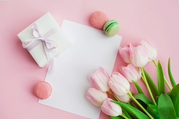 Obraz na płótnie Canvas A bouquet of tulips, a gift card on a pink background. Gift. A box with a gift. International Women's Day. Holidays. Spring. Macaroons.
