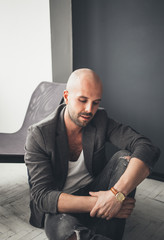 Fototapeta premium A bald man in a suit sitting indoors