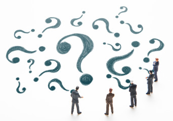 Group of miniature people and question mark.