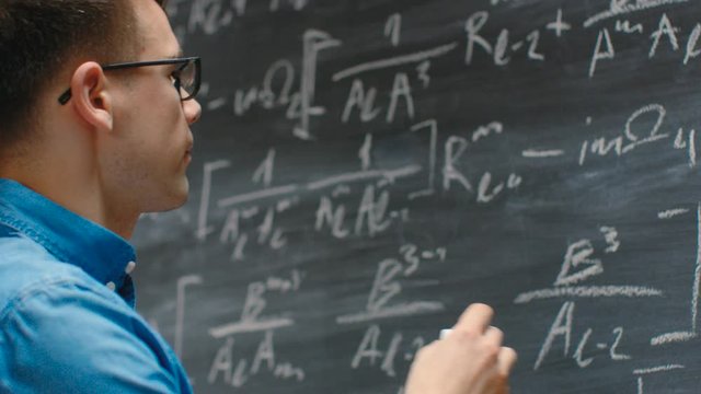 Brilliant Young Mathematician Writes Long and Math Equation/ Formula on the Blackboard. 
