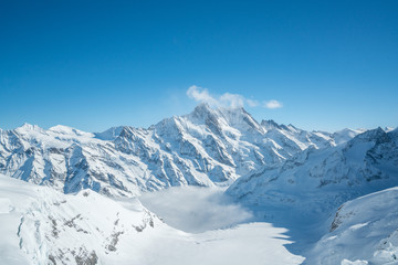 Fototapeta na wymiar Jungfraujoch, Part of Swiss Alps Alpine Snow Mountain Landscape. Jungfrau in Switzerland on sunlight with blue sky clouds. - Top of Europe.