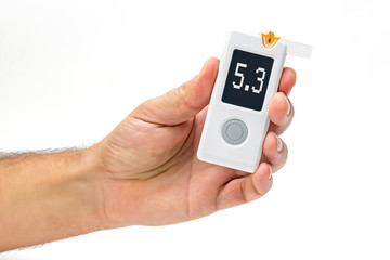 Man holds in hand glucometer measures blood sugar level. Hand holding Blood Glucose Meter