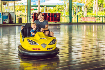 Father and son having a ride in the bumper car at the amusement park