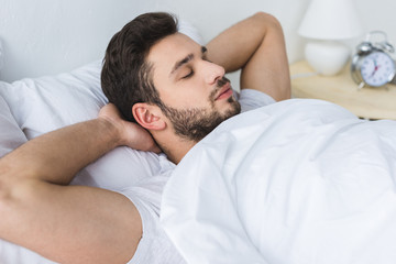 Fototapeta na wymiar bearded man relaxing on bed in bedroom