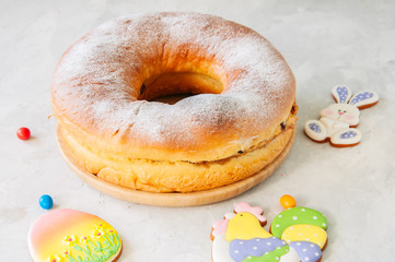 Reindling - Austrian or German festive baking for Easter. Ring cake served on a wooden plate on a white stone background.