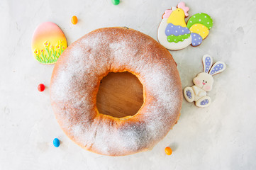 Reindling - Austrian or German festive baking for Easter. Ring cake served on a wooden plate on a white stone background.