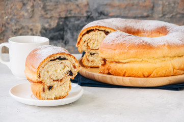 Reindling - Austrian or German festive baking for Easter. Ring cake served on a wooden plate on a white stone background.