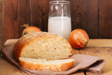 Slice of homemade onion bread on a napkin. Wooden background. Rustic style.