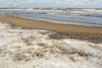 frozen beach in cold winters day with colorful sky and ice.