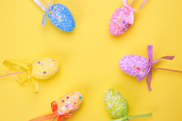 Fototapeta na wymiar Easter holiday background. Pastel coloured decorated easter eggs on a bright yellow background