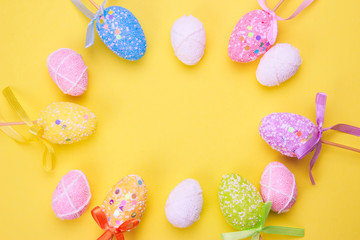 Easter holiday background. Pastel coloured decorated easter eggs on a bright yellow background