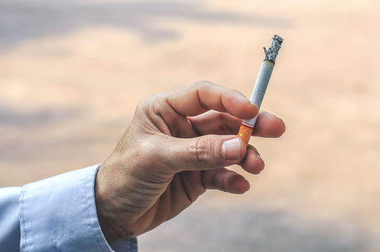 Young man smoking a cigarette. Cigarette smoke spread.