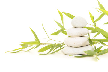 Pile of white stones with bamboo leaves on a white background