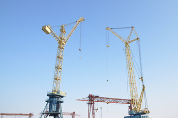 Several tower cranes. gantry cranes against the blue sky. Russia