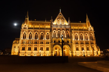 Hungarian Parliament Building At Full Moon Night In Budapest, Hungary