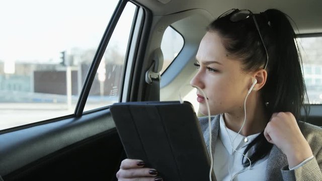 Young Businesswoman Holding a Tablet in the Moving Car