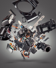 Flying broken camera parts on gray background