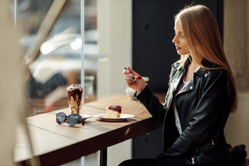 Pretty girl hold a plate of delicious cake and waer glasses. Sun shine photo with girl eat her cake