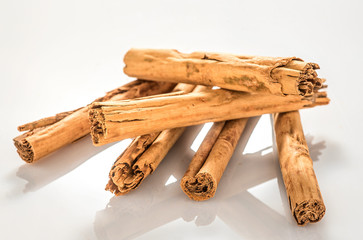 group of cinnamon sticks isolated in a white and lucid background 
