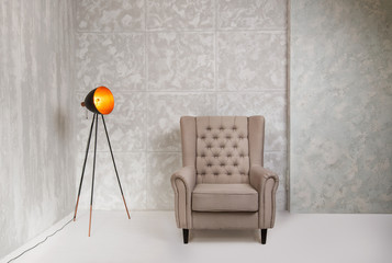 Minimalistic gray interior with armchair and vintage lamp