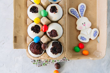 Dark chocolate brownie dessert in egg shells. Easter or funny kids party concept. White stone background.