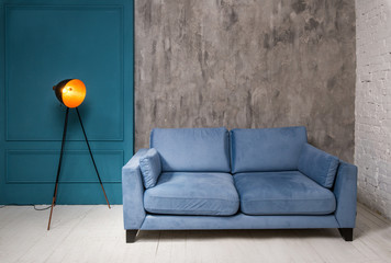 Trendy apartment with blue couch and vintage lamp