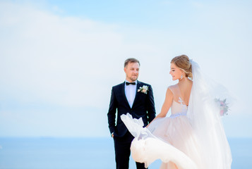 Bride whirls standing with groom before a great sea view