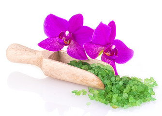 green sea salt in wooden spoon and flower