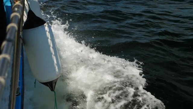 Slow motion of boat with a bouy cruising through the ocean water