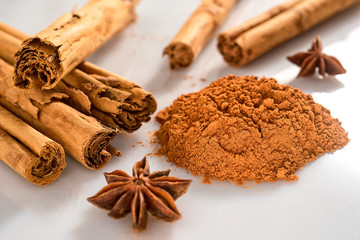 group of cinnamon sticks  isolated in a white background with star anice and powder