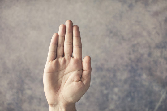 Male hand showing stop sign