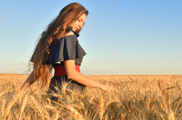 A young girl strolls among the rye's ears