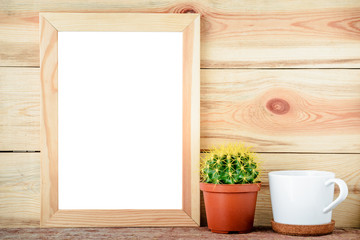 empty wooden frame with cactus and white cup on wooden background