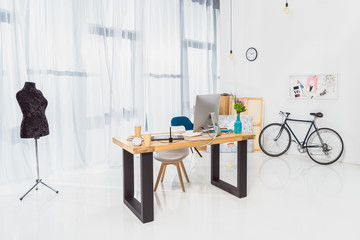Room interior with working table and bicycle by the wall