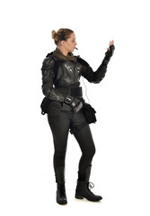 Fototapeta premium full length portrait of female soldier wearing black tactical armour with arms raised, isolated on white studio background.