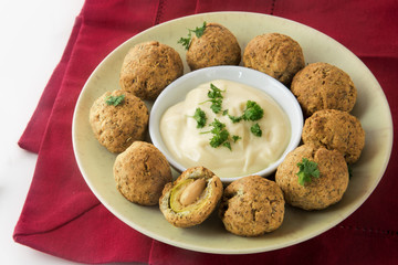 Green olives baked in parmesan dough with a creamy garlic dip on a red napkin, finger food for the party buffet, spanish tapas appetizer, selected focus