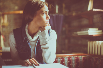 Student girl at home tired of learning and looking away.
