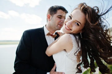 Wedding couple at breathtaking landscape with rock and lake.