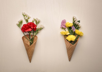 Composition of fresh flowers in two ice cream cones