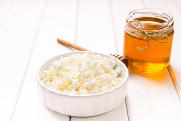 milk cottage cheese with honey on white wooden table. Selective focus image. Copyspace for your text.