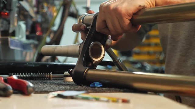 Close-up of man hands adjusting a mountain bike in his workshop.