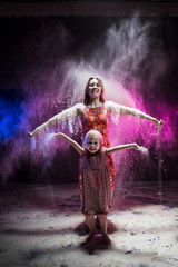 Fototapeta premium Young mother and small daughter during photoshoot with flour