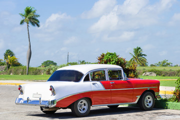Rot weisser amerikanischer Oldtimer parkt unter blauem Himmel in Varadero Kuba - Serie Cuba Reportage